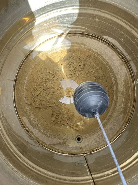 清洗前的水塔內部，底部累積厚厚一層泥沙沉積物